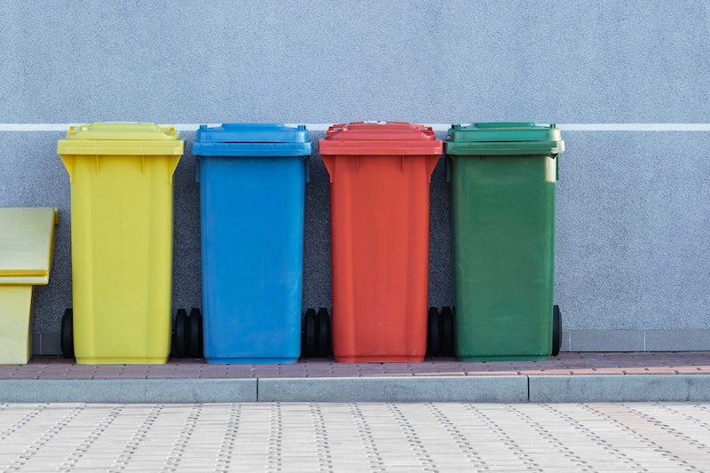 Vier kliko's met verschillende kleuren op een rij op de stoep